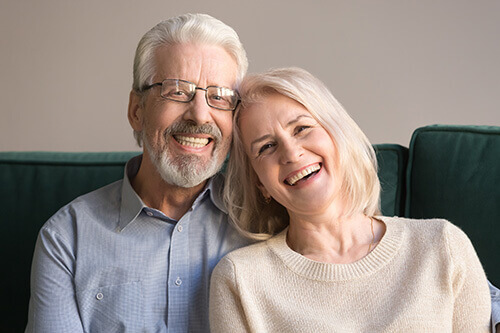 Happy Older Couple Showing Off Their Dental Implants